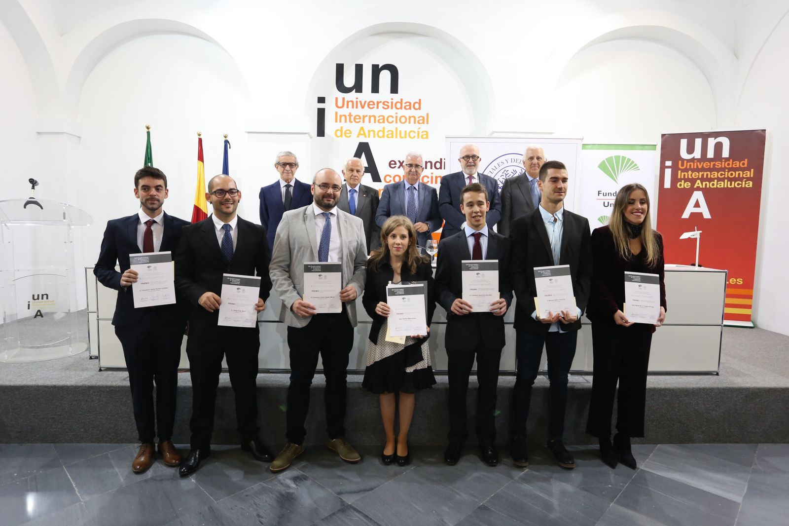 Los siete premiados a la mejor trayectoria académica universitaria junto a los organizadores y patrocinadores.