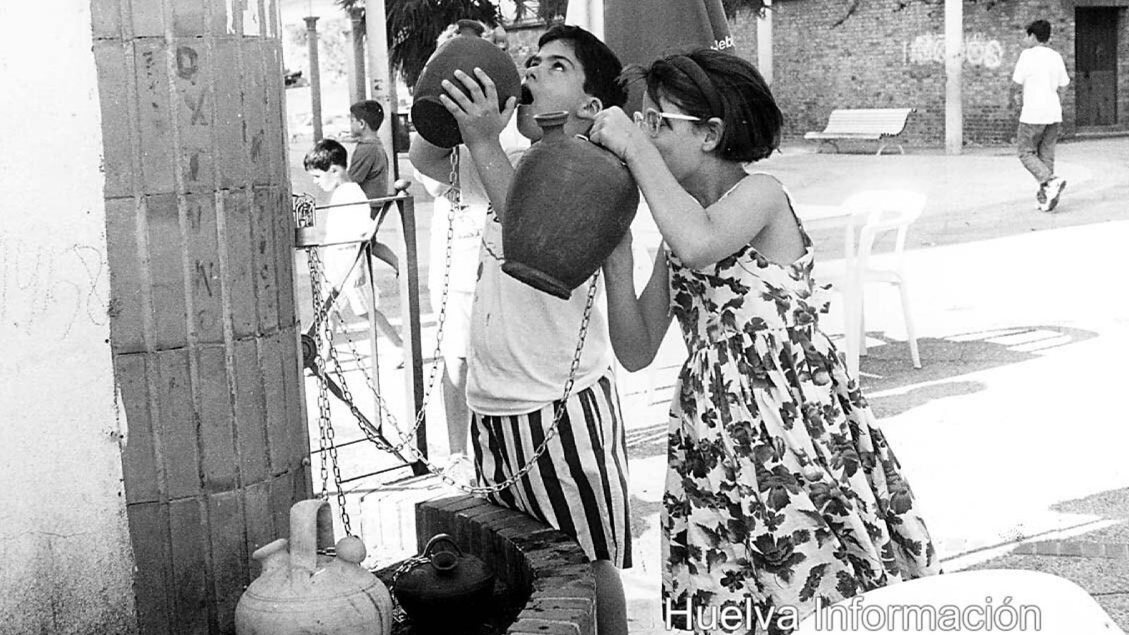 Niños bebiendo agua en el Paseo del Piojito de los botijos que estaban atados con cadenas a las barandillas de la Piterilla, en 1998.