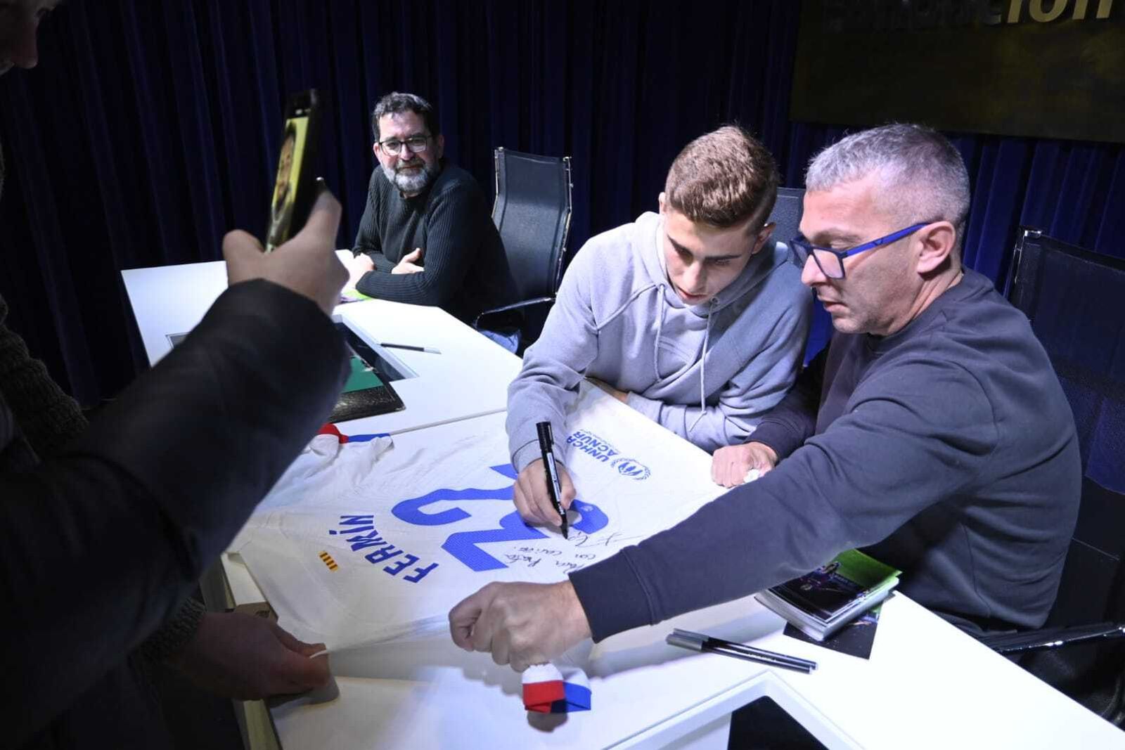 Fermín López firma una camiseta del FC Barcelona con su nombre.