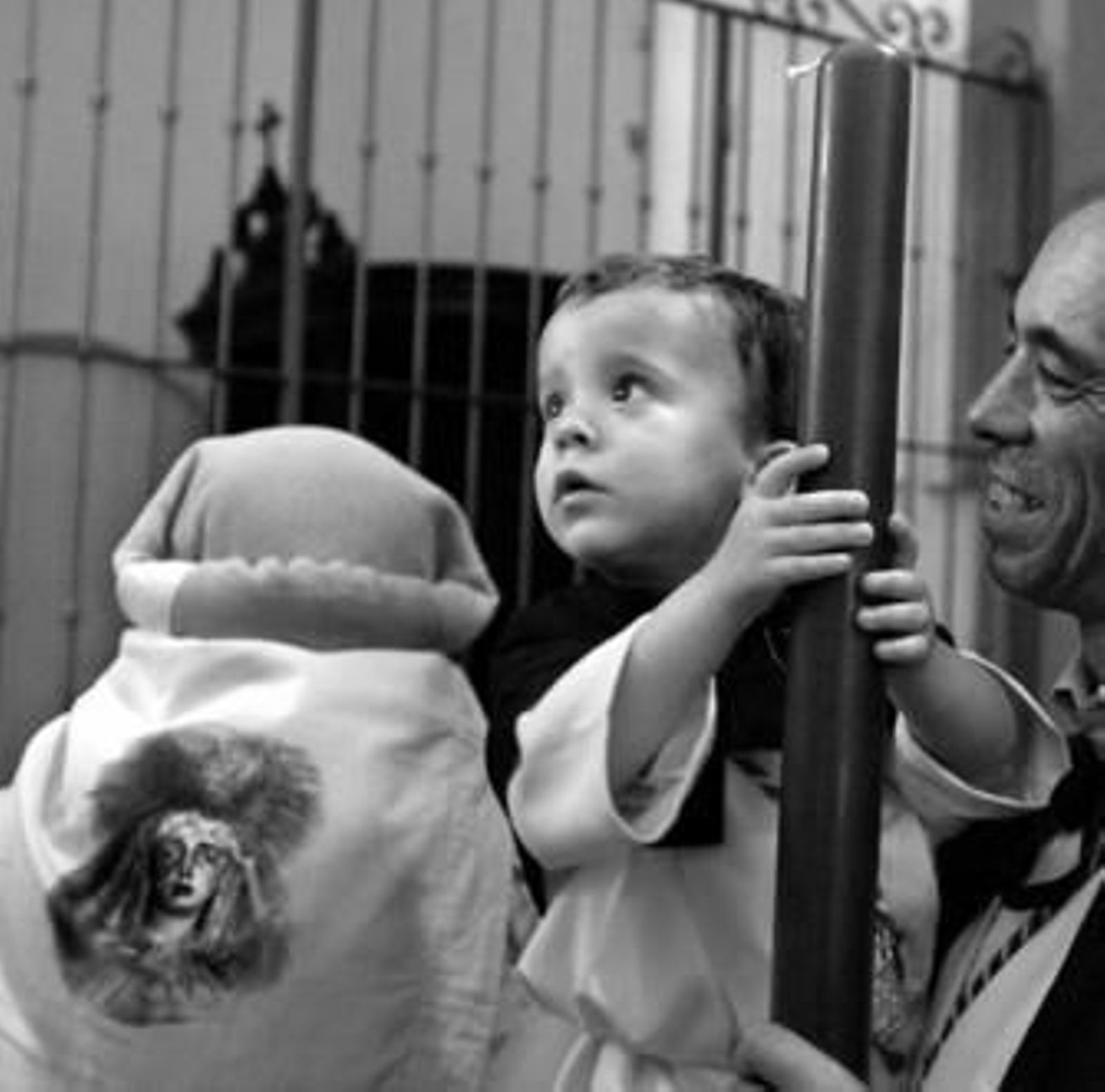 Un monaguillo juega con un cirio antes de la salida.