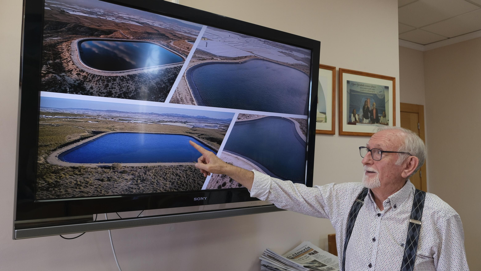 Antonio López, presidente de la CUCN, señala imágenes de balsas de almacenamiento de agua de la comunidad.