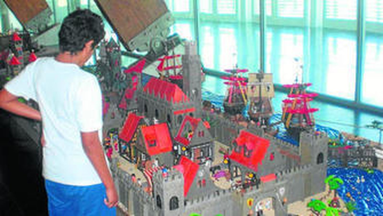 1. Un niño observa una gran maqueta de la exposición. 2. Detalles de las figuras que componen uno de los dioramas. 3. Dos visitantes comentan los detalles que se aprecian en el diorama que representa la llegada de Julio César a Egipto.