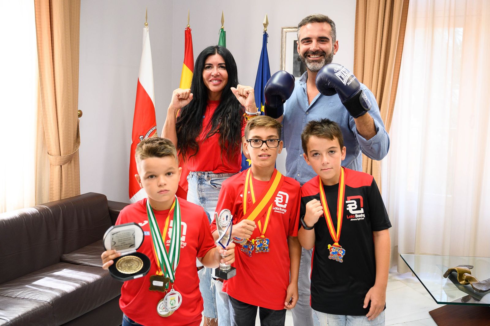 El alcalde con unos guantes junto a los pequeños y la responsable del club Lola Boxing