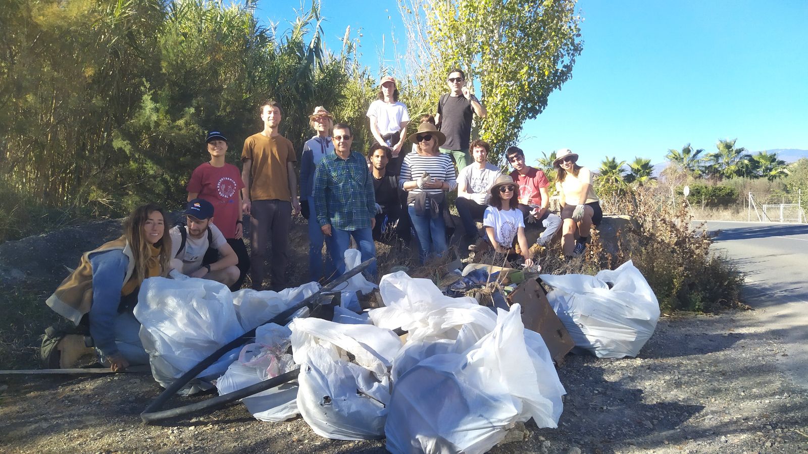Los voluntarios con las bolsas llenas de residuos recogidos del cauce del río.