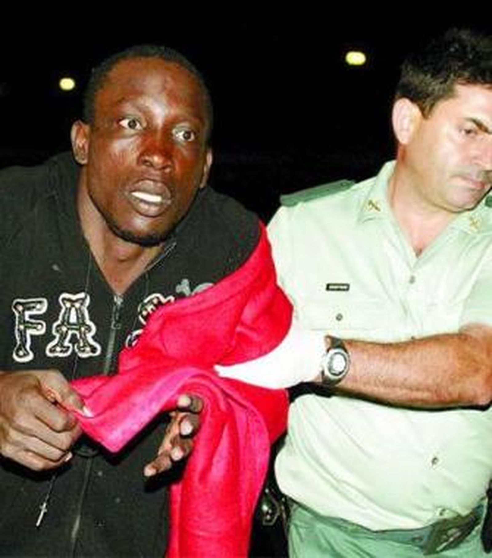 Un guardia conduce a uno de los inmigrantes, en estado de 'shock'.