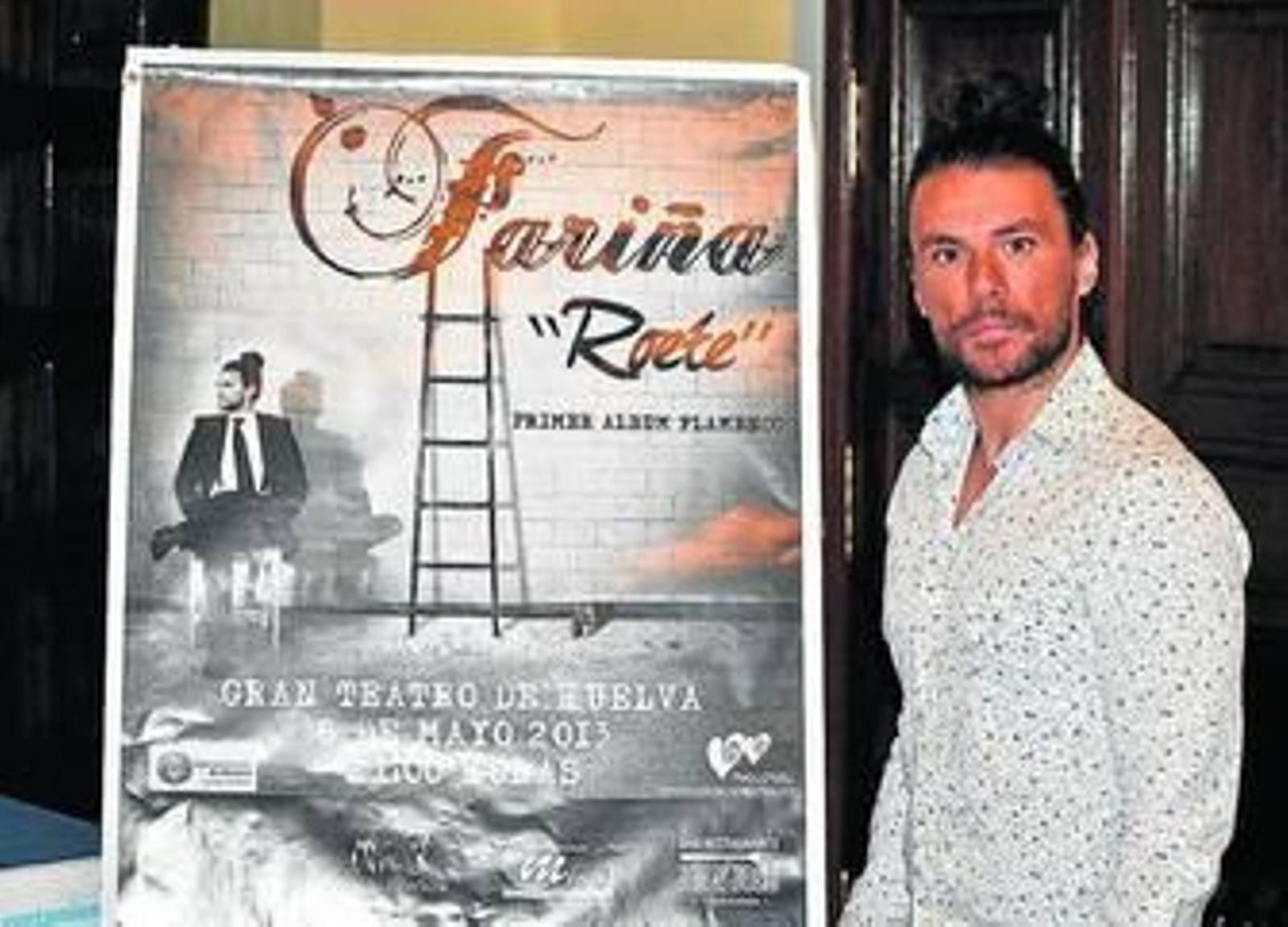El artista onubense Fariña junto al cartel del concierto en el Gran Teatro.