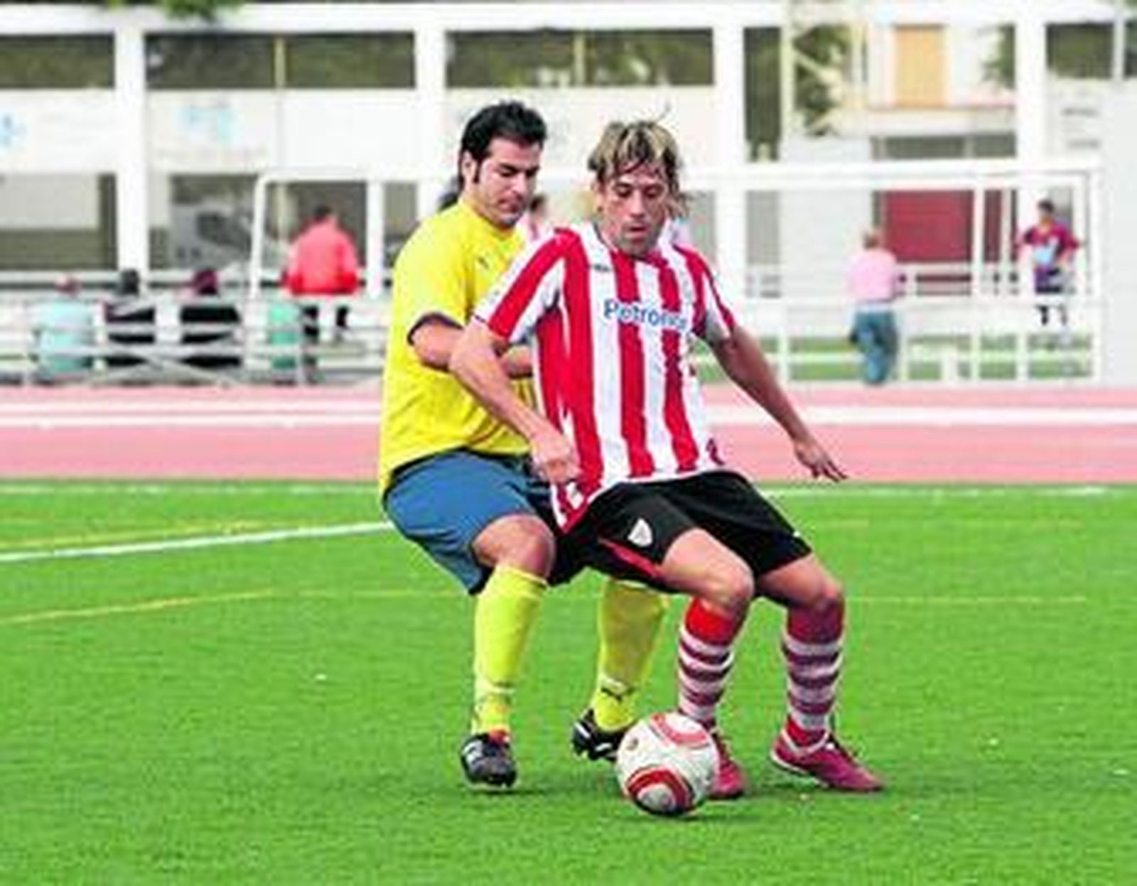 Un futbolista del Deportes Romero aguanta el balón ante la presión de un rival.