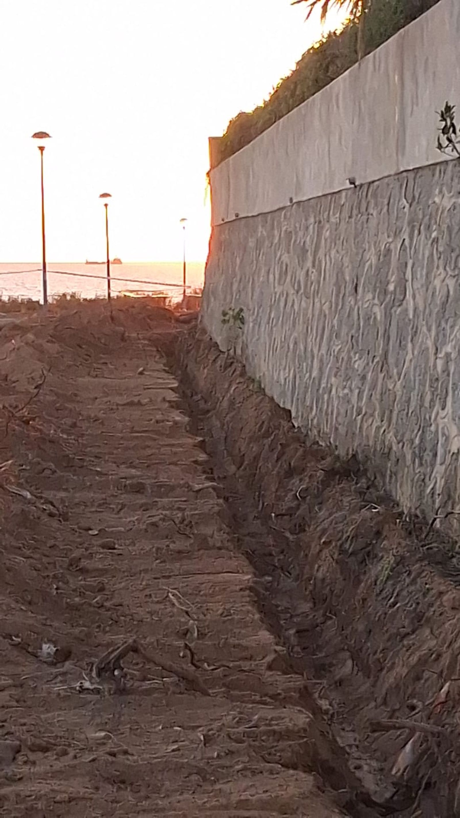 Una de las zanjas, pegadas al muro de una vivienda.