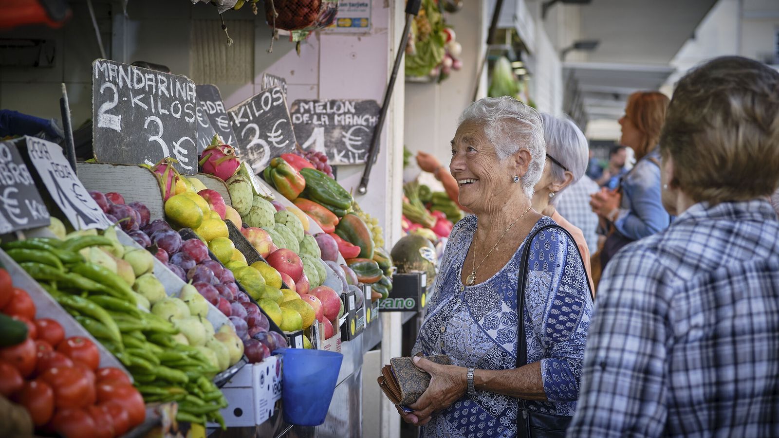 Señoras comprando en el puesto de frutas y verduras