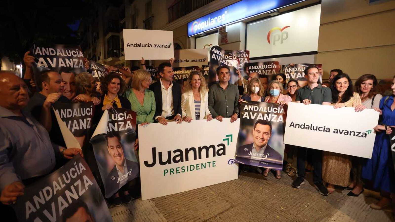 Candidatos y militantes del PP con el cartel de campaña.