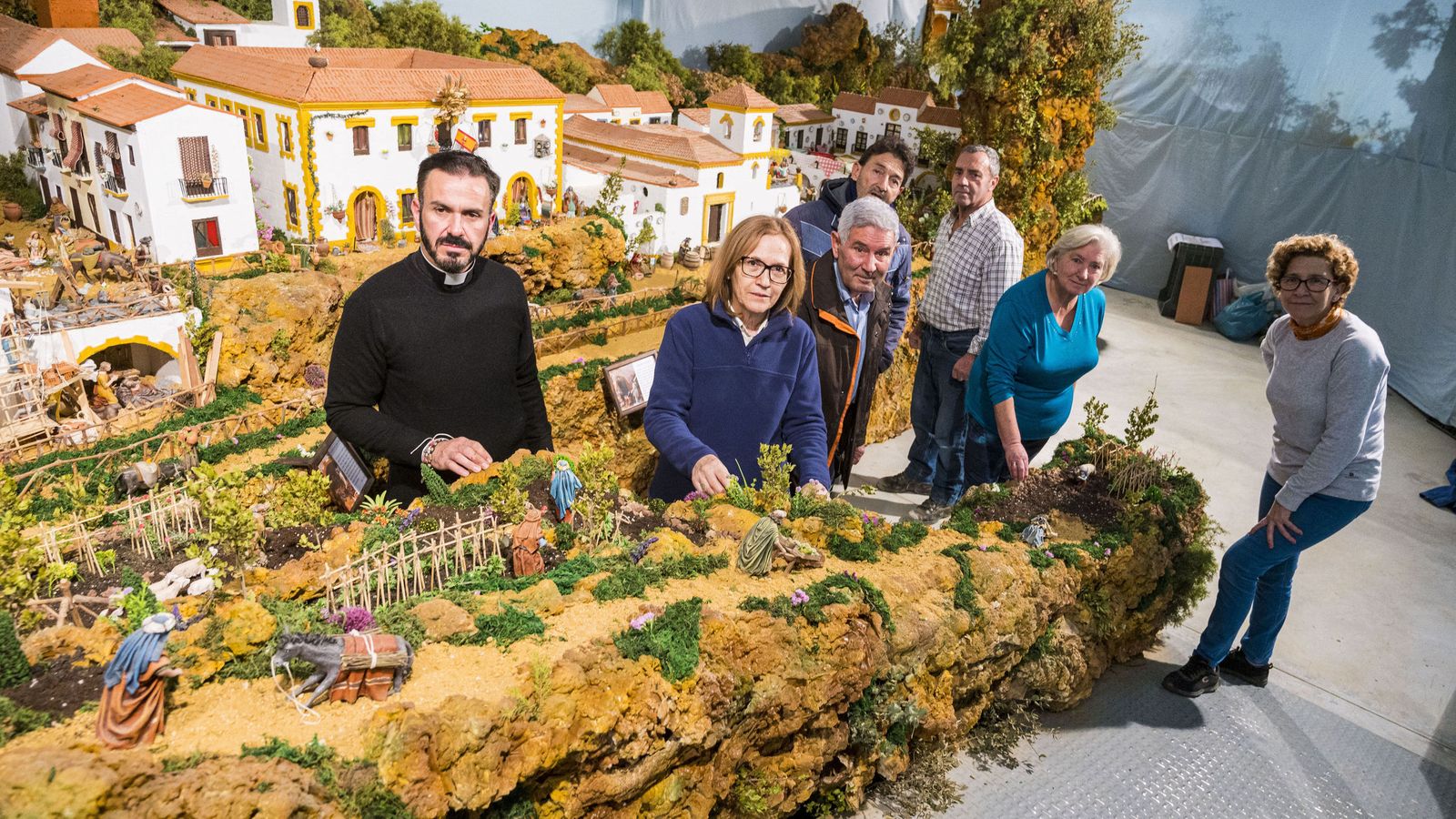 Los vecinos que han colaborado con el belén, junto al párroco Víctor Valero.