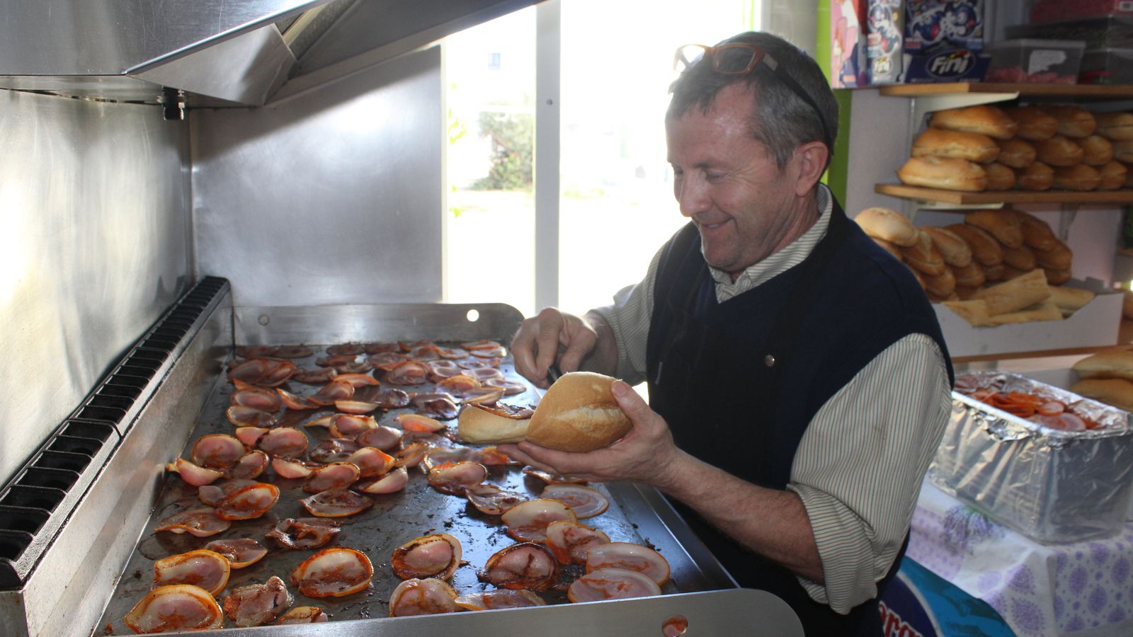 Jose prepara en la plancha los famosos bocadillos de panceta o magreta.