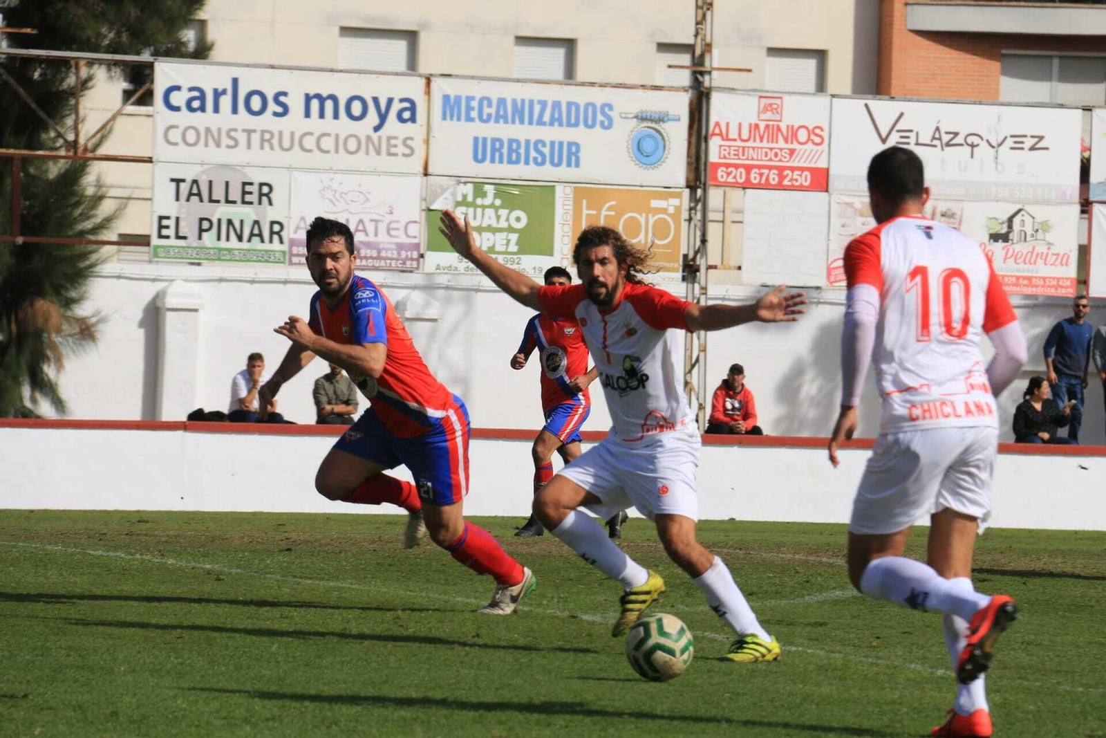 Dani Fornell recibe un centro de Josemi Caballero, de espaldas en la imagen, vigilado por Pablo Oliveira.