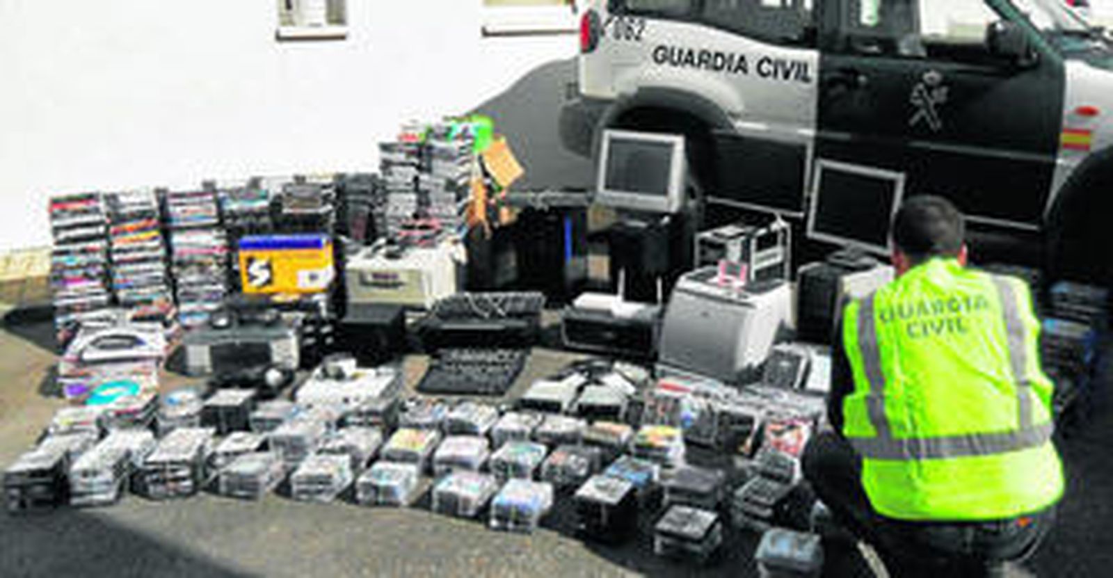 Un agente inspecciona el material incautado a la organización que falsificaba DVD.