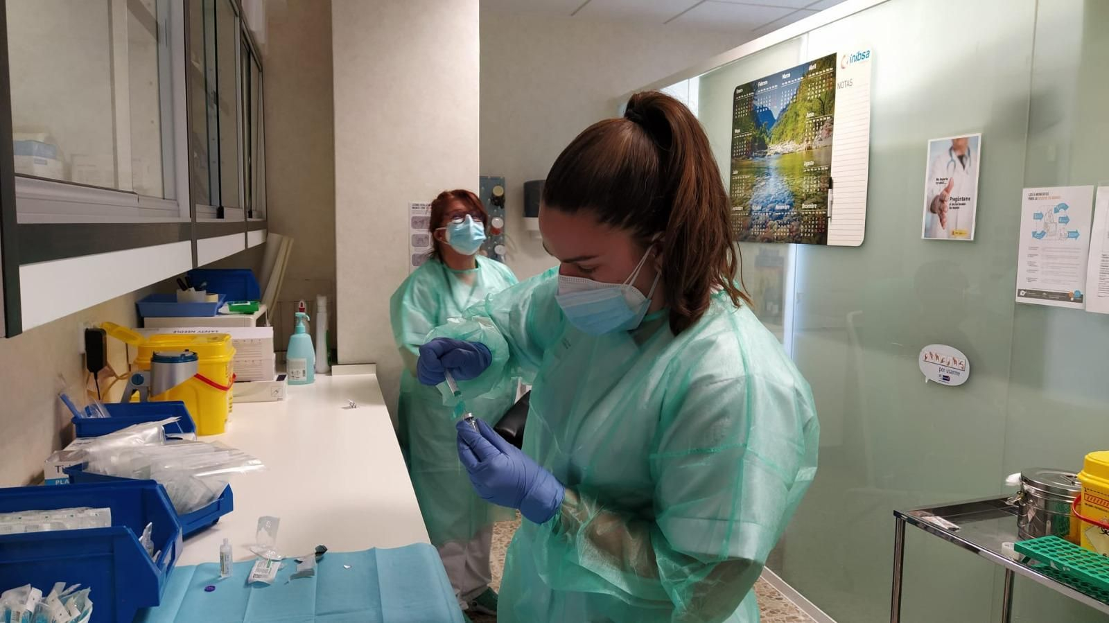 Sanitarias preparan la vacuna para su administración.