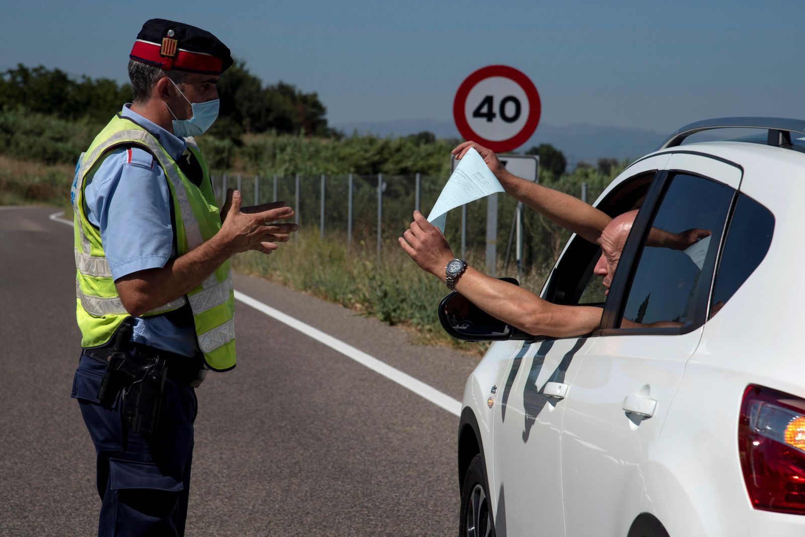 Un Mosso d'Esquadra realiza un control de carreteras en la comarca del Segrià, confinada por los rebrotes de coronavirus.
