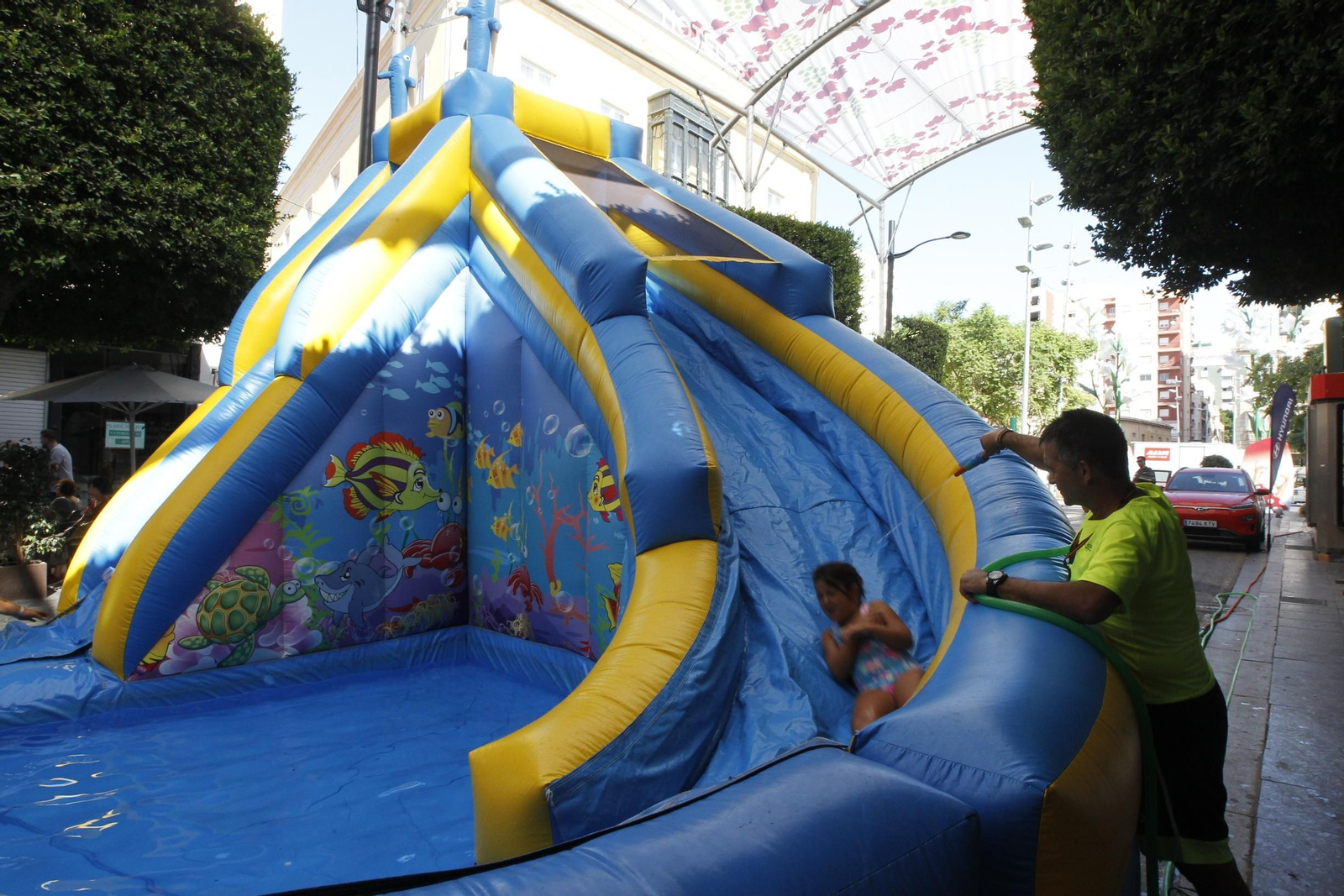 Una niña se dispone a caer a la piscina en la que desembocaba uno de los toboganes habilitados en el Paseo.