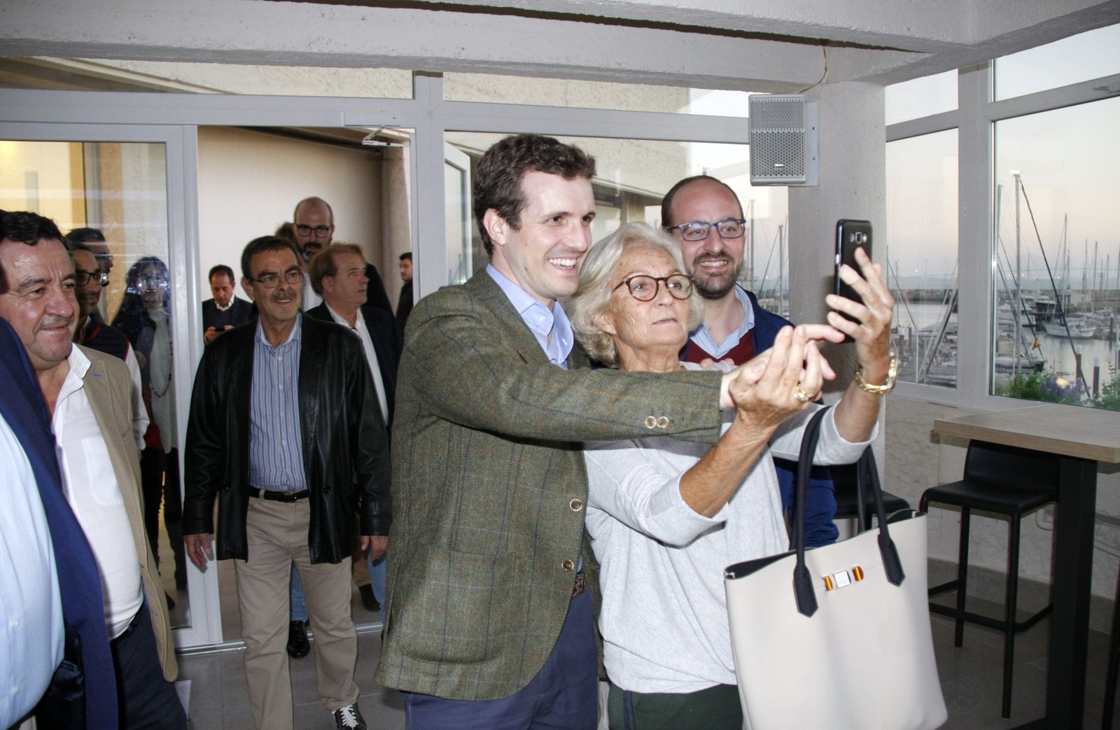 Pablo Casado haciendose un 'selfie' con una de sus simpatizantes a la entrada del salón en la planta alta en la terraza del hotel Puerto Sherry.