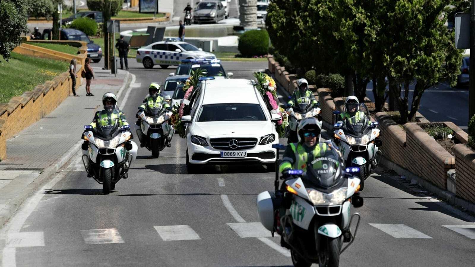Agentes de la Guardia Civil de Tráfico escoltan la llegada del coche fúnebre.