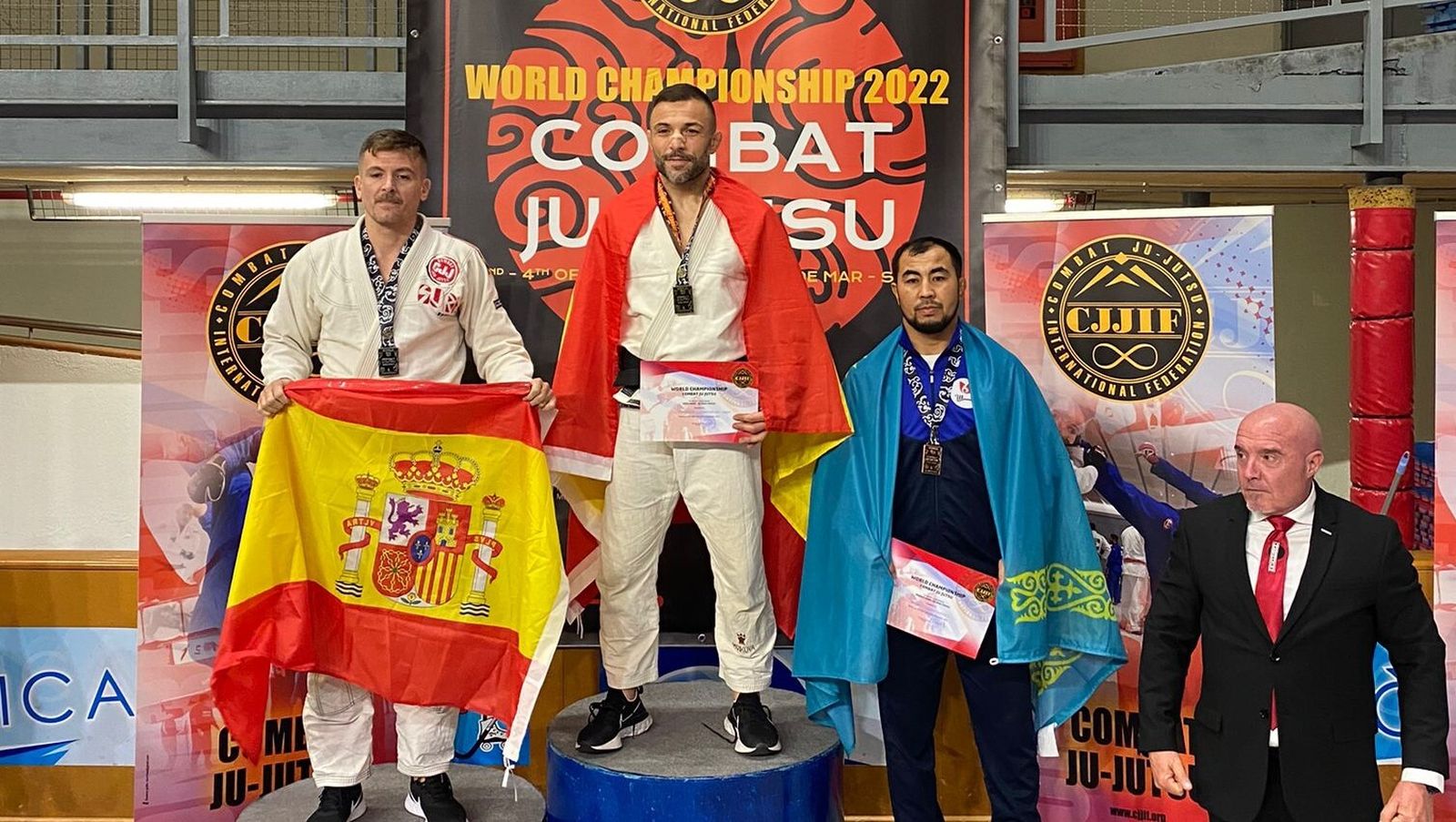 Mariscal (i) con la bandera de España en el segundo cajón del podio.