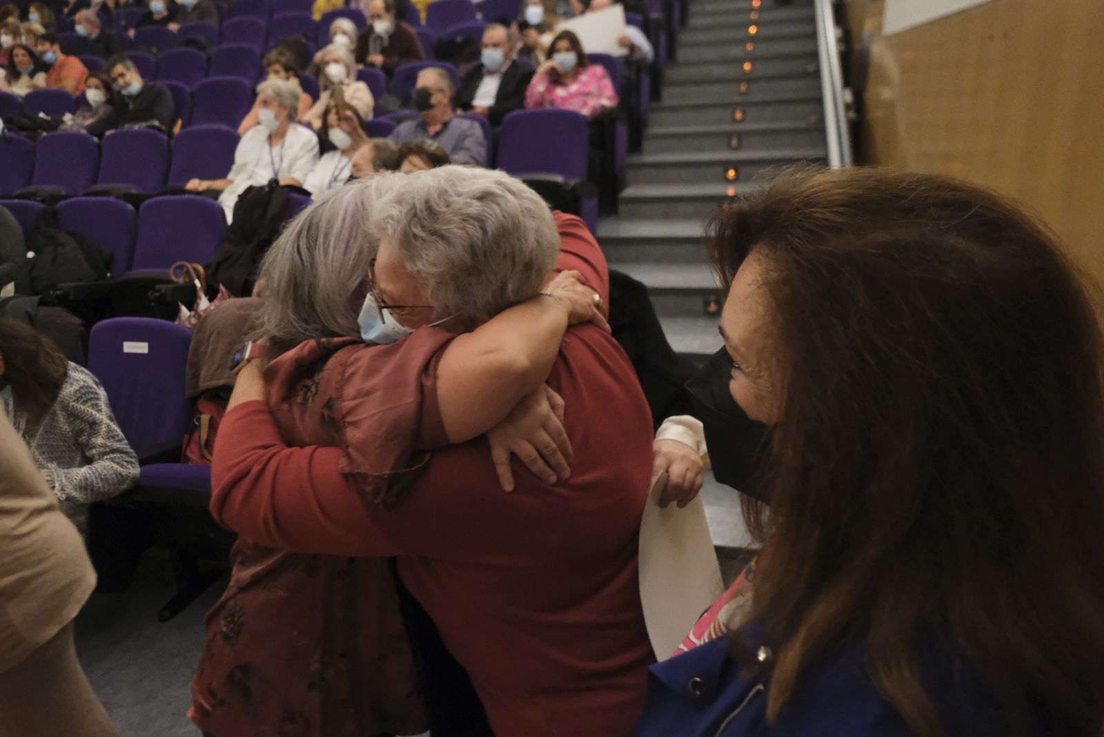 Dos mujeres se abrazan en el acto de homenaje a los jubilados de Reina Sofía.