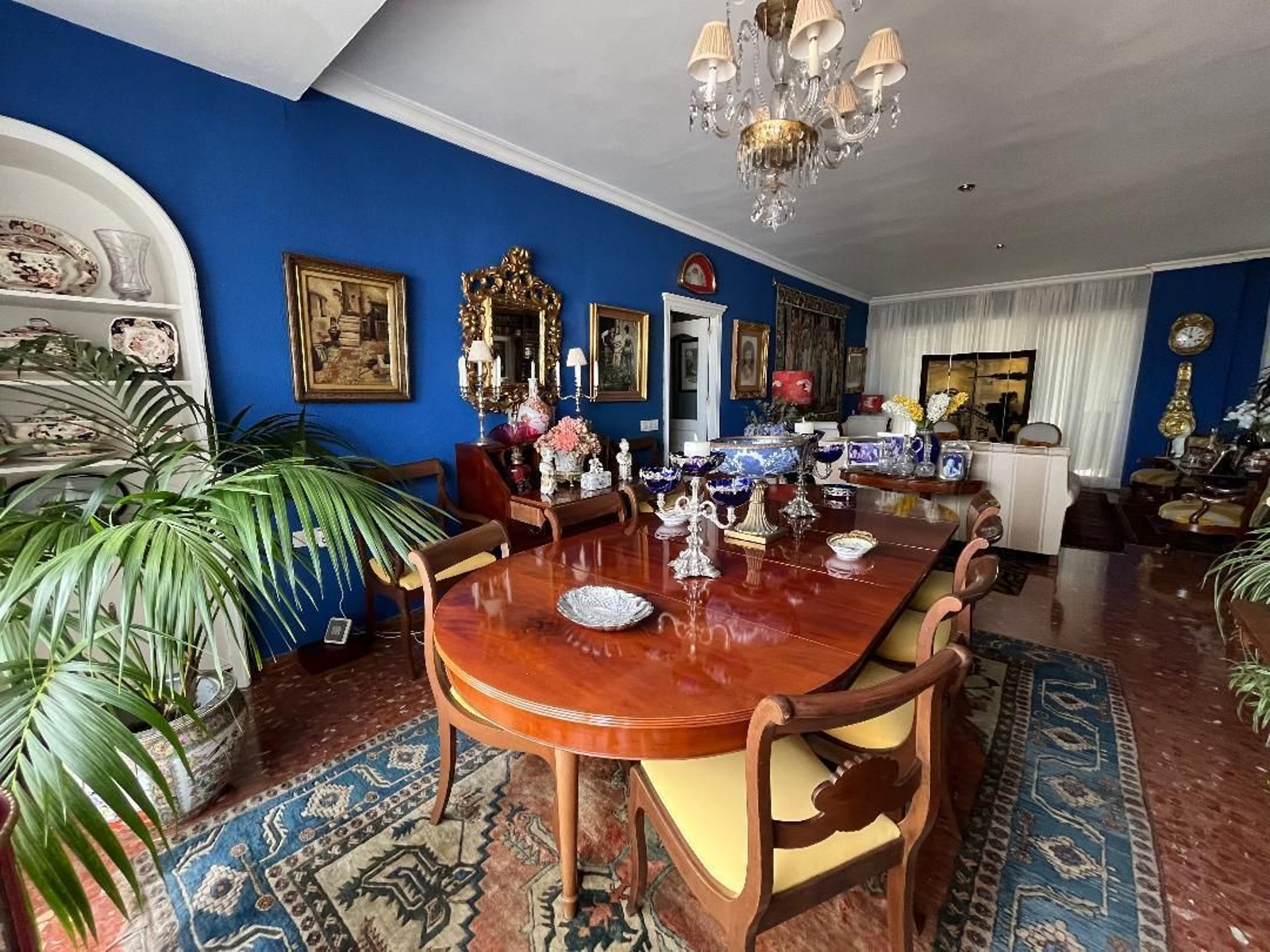 Comedor. Mesa inglesa  de caoba del siglo XIX sobre la que se apoyan unos antiguos centros de plata y cristal de color azul cobalto.