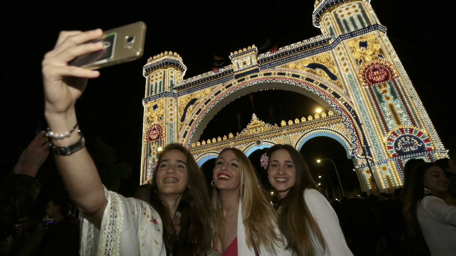 Tres mujeres se hacen un 'selfie' en la portada de la Feria.