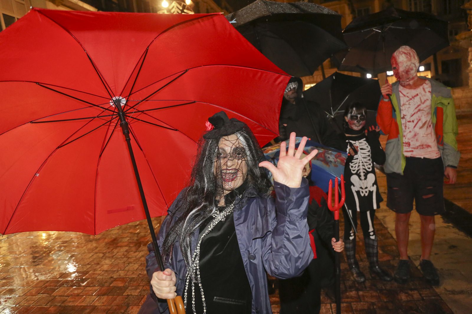 Una mujer celebrando anoche Halloween en Málaga, con su paraguas.