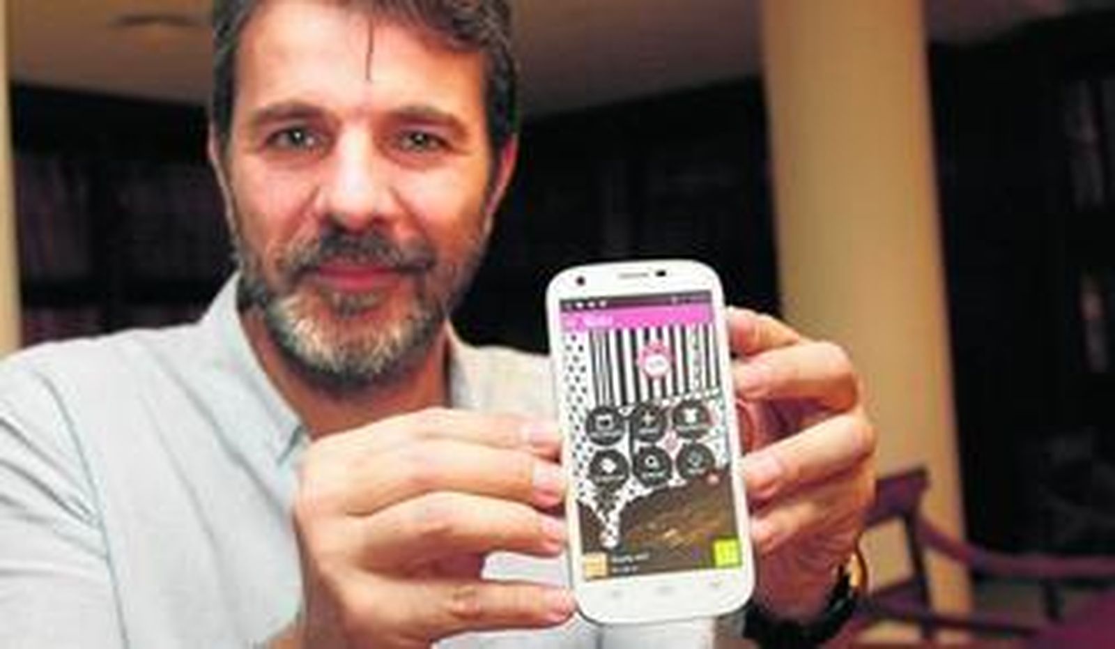 Julio García muestra el móvil con su aplicación.