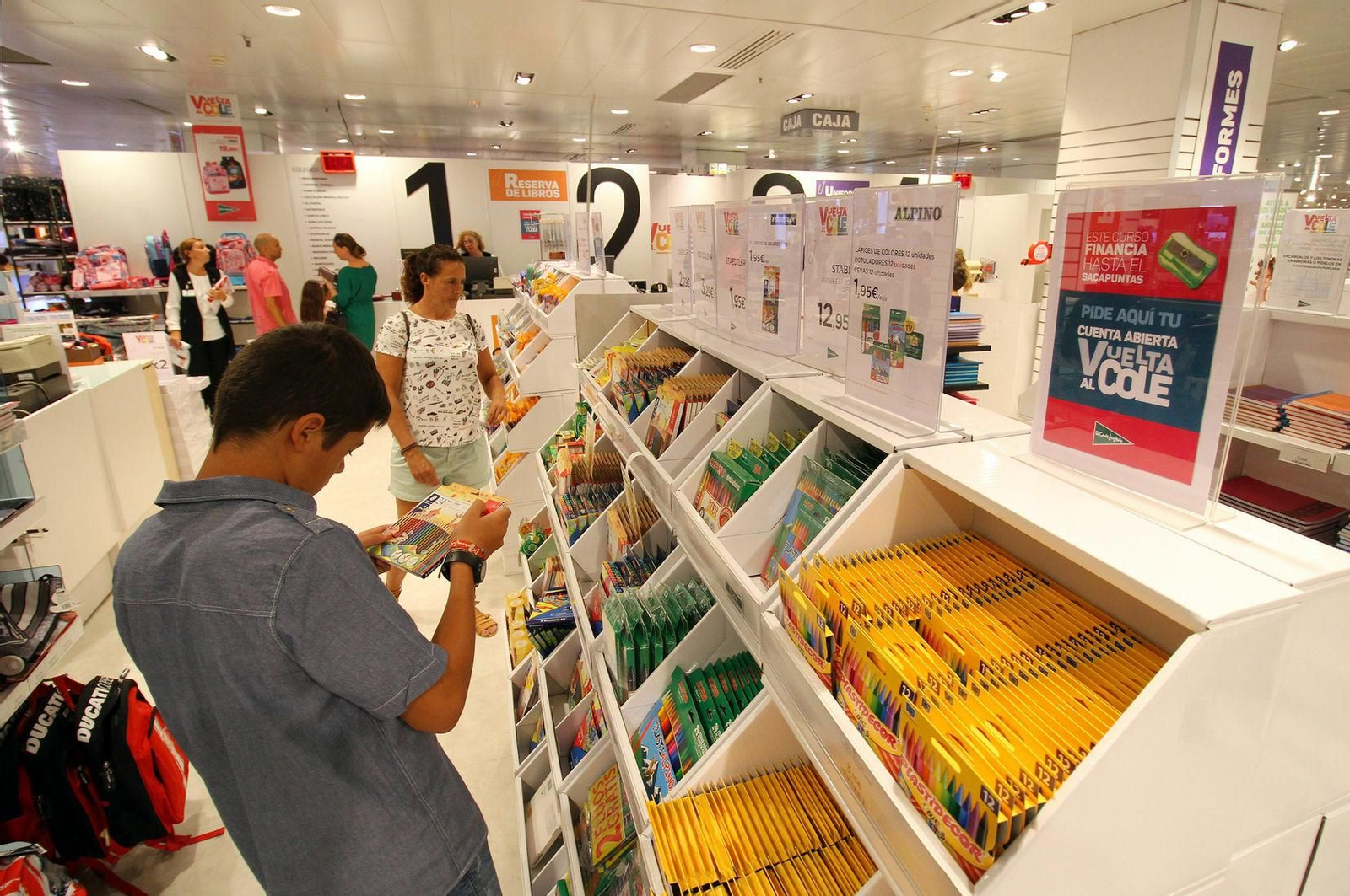 Un alumno mira un paquete de lápices en la sección de papelería de El Corte Inglés.