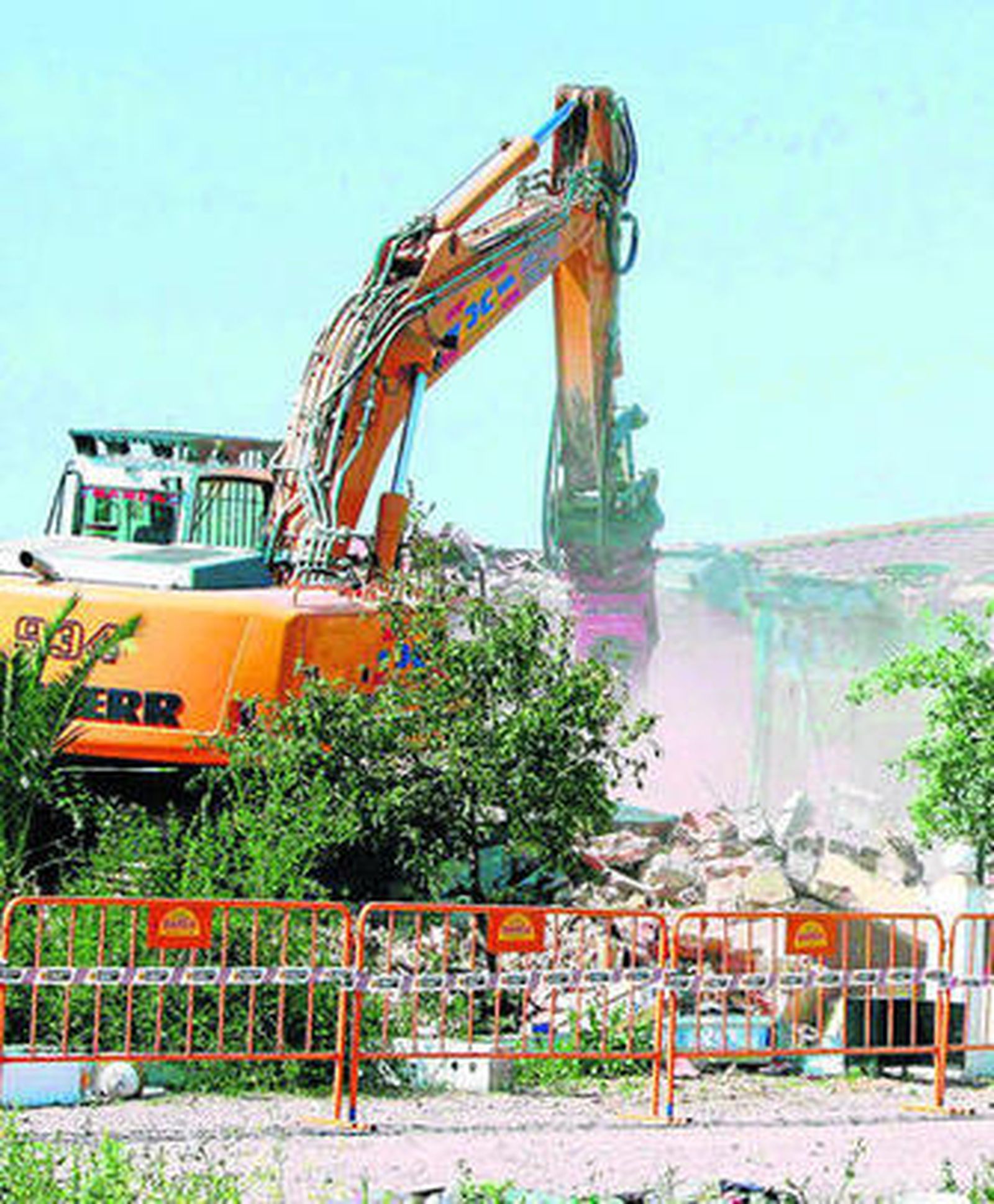 Una maquina excavadora derriba una de las viviendas de las cercanías del aeropuerto.