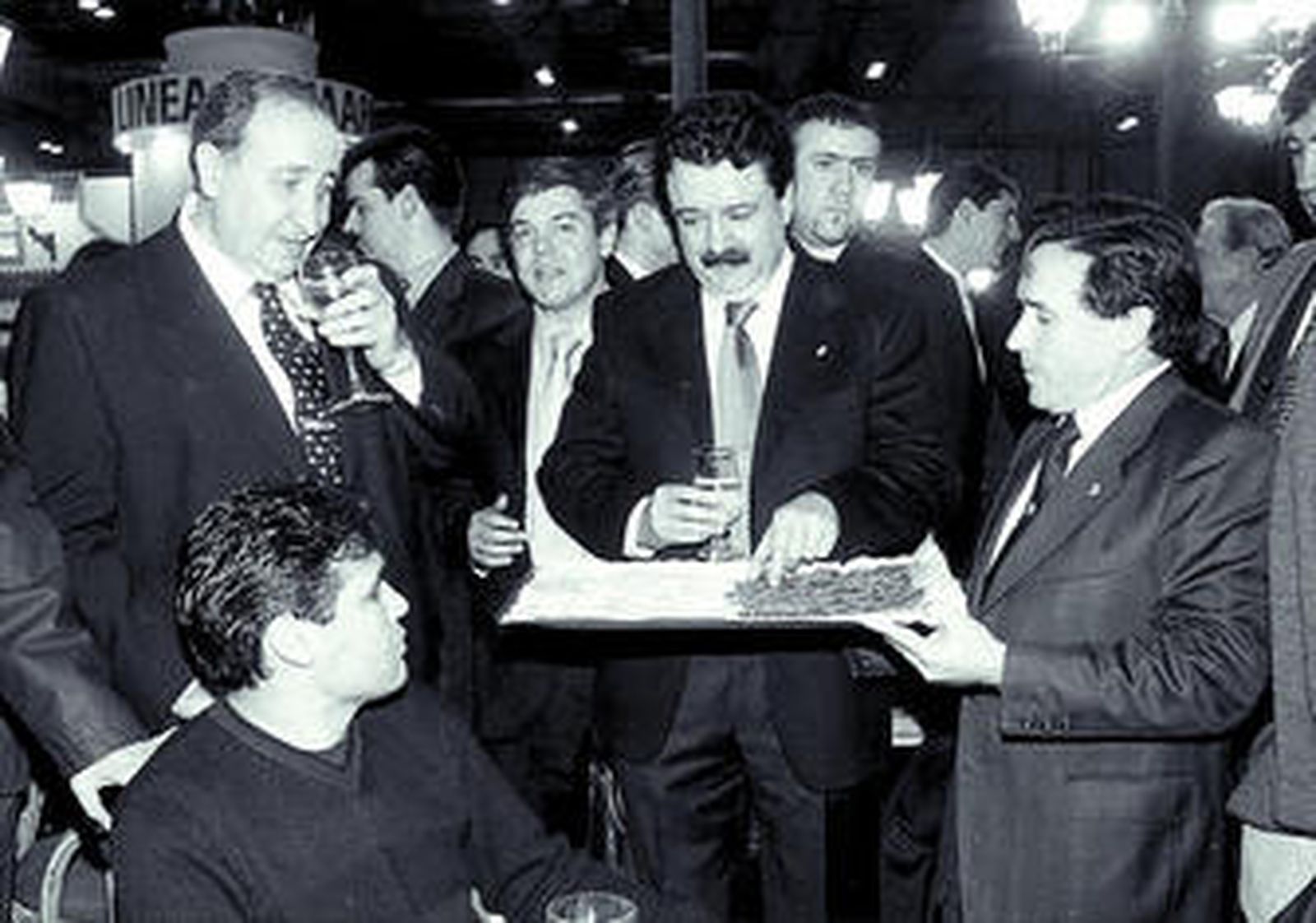 Ramón Mesas, a la derecha, en Fitur en 2002, sirviendo canapés a Jesús Gil y Juan Carlos Juárez.