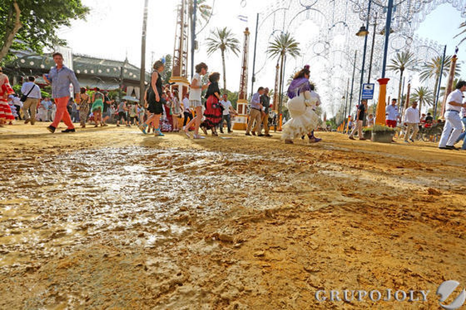 El asentamiento del albero en el Real del González Hontoria es necesario, por lo que debería haberse procedido antes al echado en el parque. Debido a la tardanza, los camiones pasan por la Feria cada poco tiempo regando las calles con la intención de que el aire no levante el albero. El resultado, como muestra la imagen superior, es que el Real termina enfangado y la gente, resbalándose.

Foto: Pascual