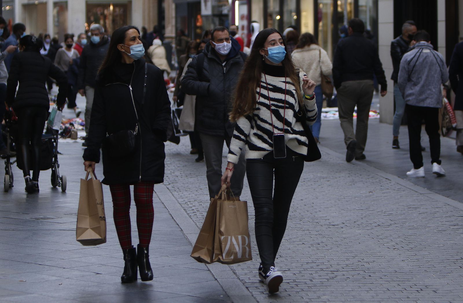 Varias personas con compras en una de las principales calles comerciales del centro de Sevilla.