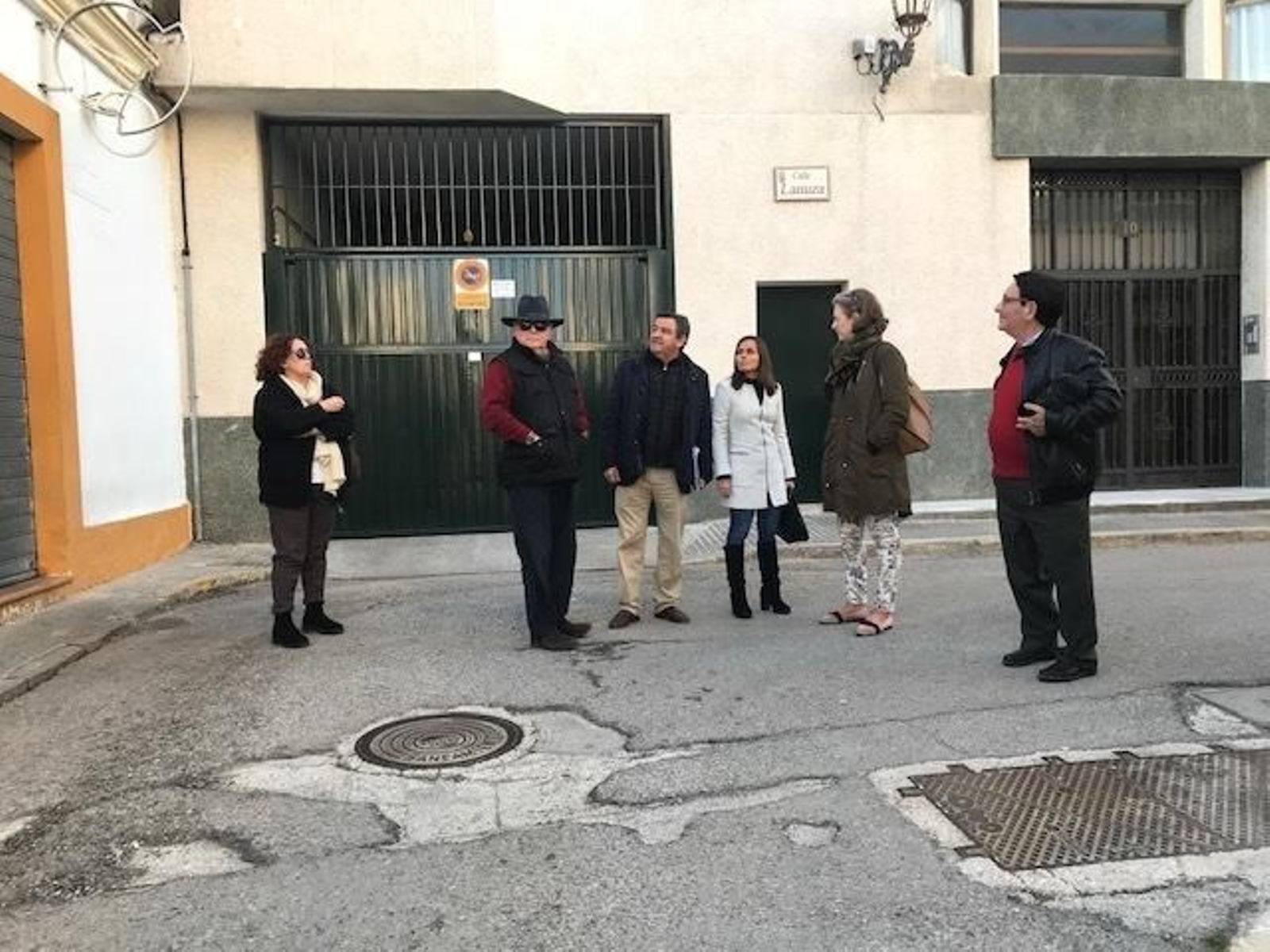 Miembros del PP y vecinos de Héroes del Baleares, en una tramo de la calle en mal estado.