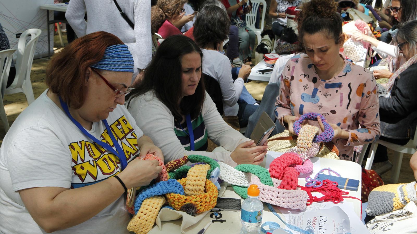 Algunas de las participantes mientras elaboran la cadena de ganchillo en los jardines del Prado.