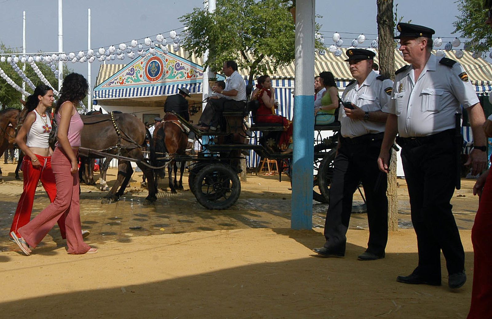 Dos agentes de la Policía Nacional patrullan las calles del real de la feria de Alcalá de Guadaíra.
