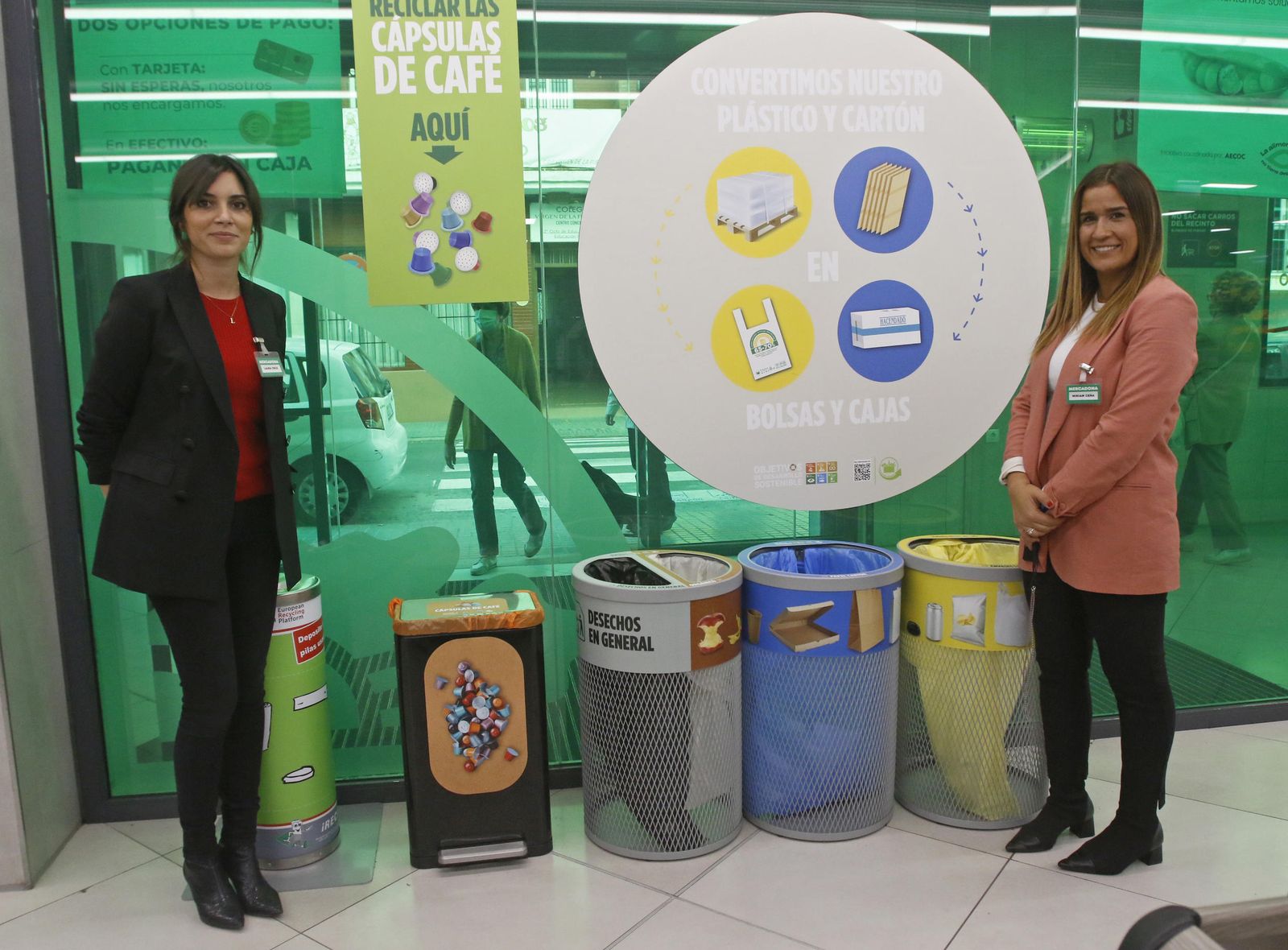 Laura Cruz, izquierda, y Miriam Ceña, junto a los contenedores ubicados a la entrada de la tienda.