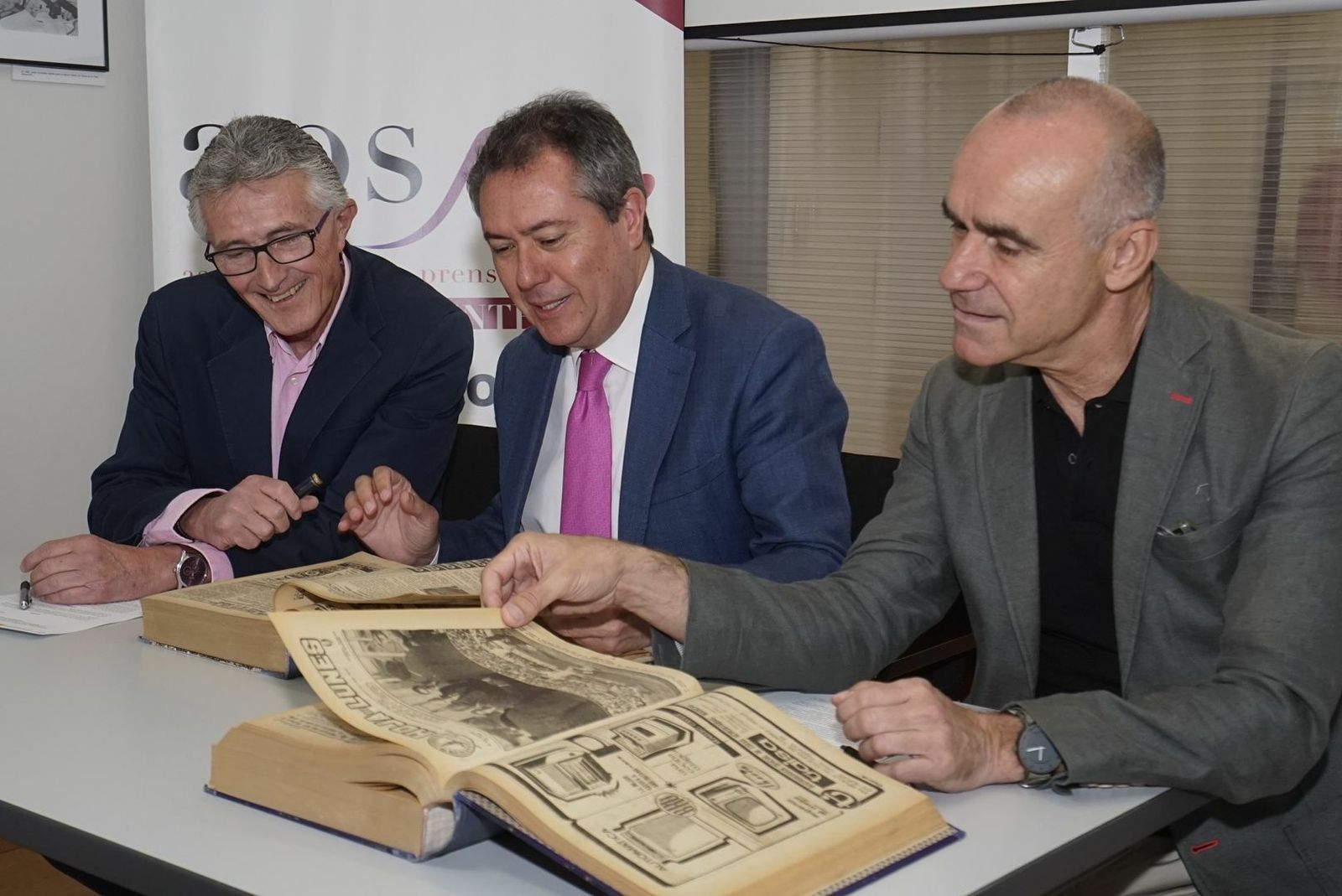 Rafael Rodríguez, presidente de la APS, Juan Espadas y Antonio Muñoz, observan algunos ejemplares de la 'Hoja del lunes' que han sido digitalizados.