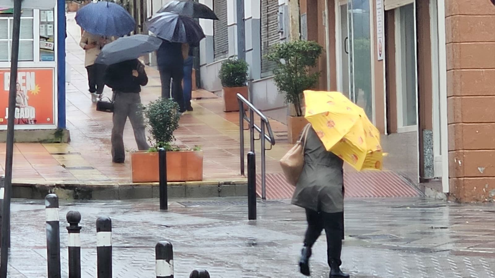 Personas bajo la borrasca en Algeciras.
