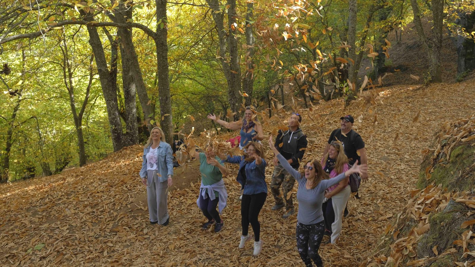Grupo de malagueños que no dudó en lanzar hojas para hacerse una fotografía otoñal.