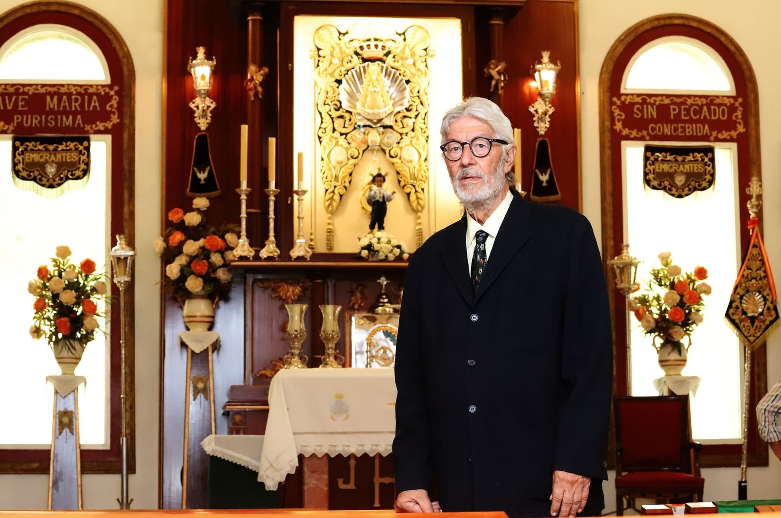 Eduardo Fernández Jurado, junto al Simpecado de Emigrantes en su capilla.