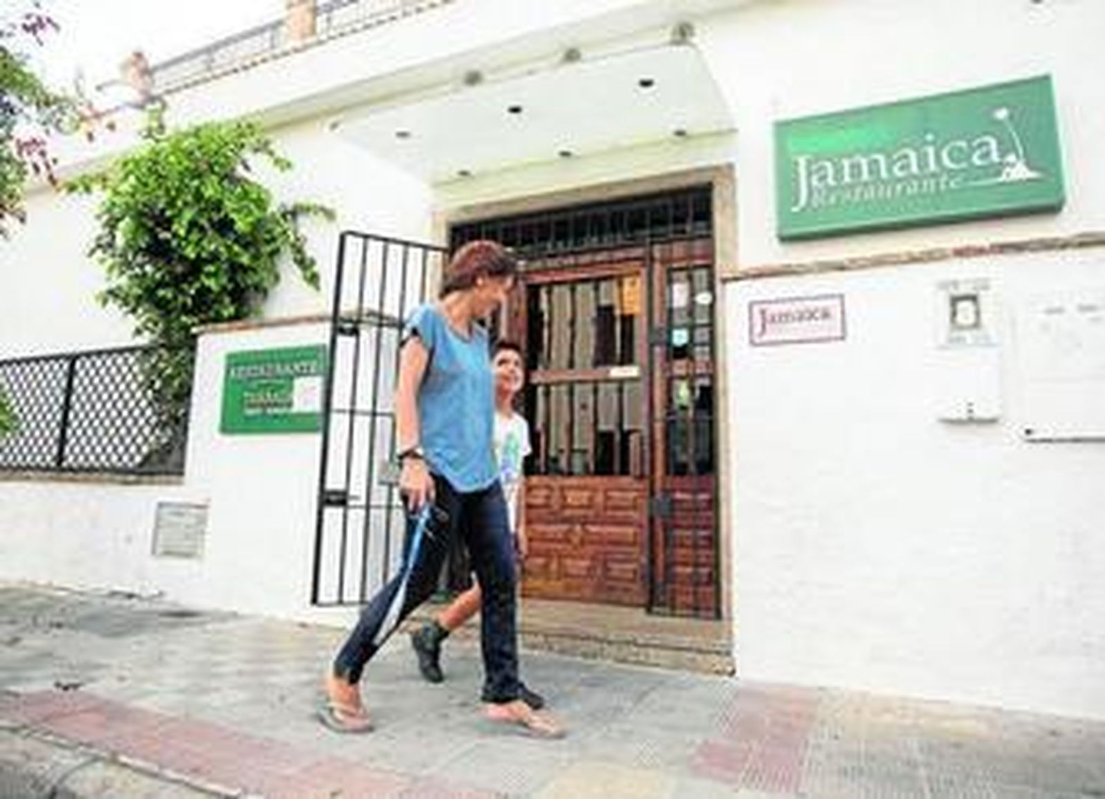Una mujer y un niño pasan ayer junto a la fachada del restaurante Jamaica.