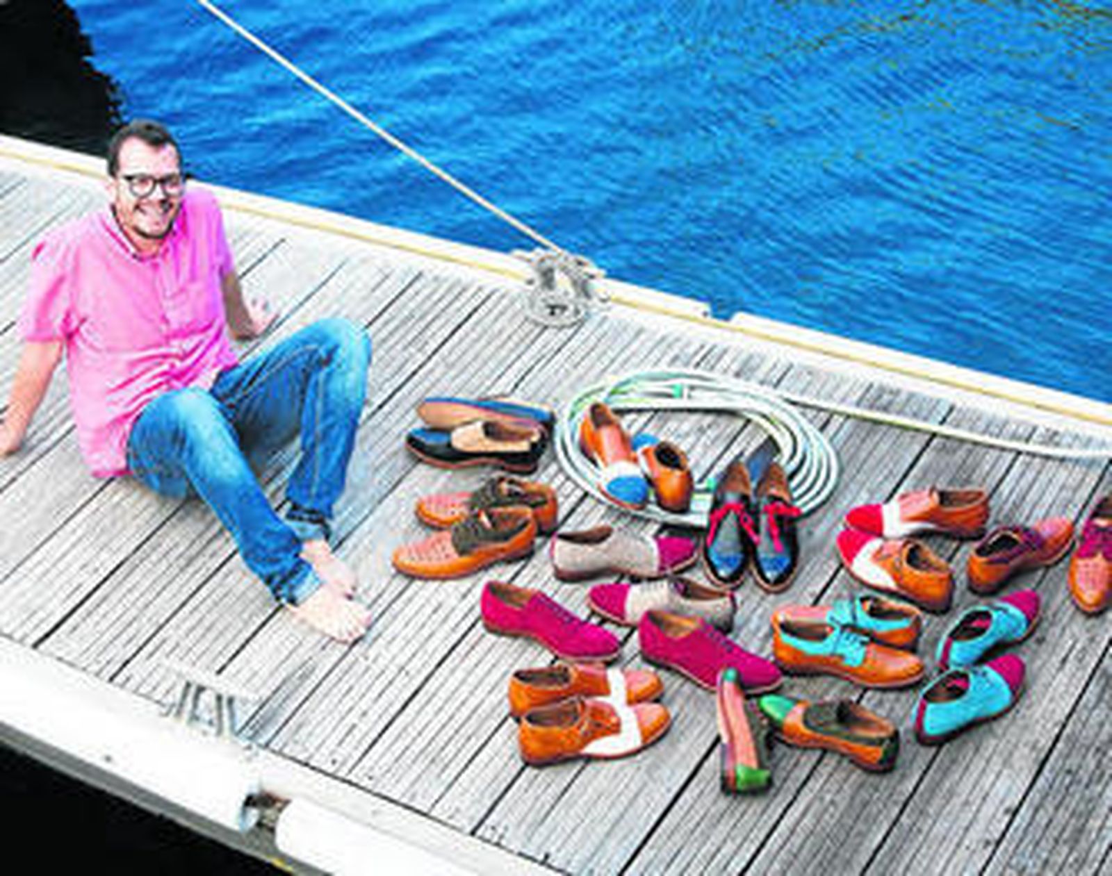 El joven artesano Abraham Zambrana posa con algunos de los zapatos que ha creado.