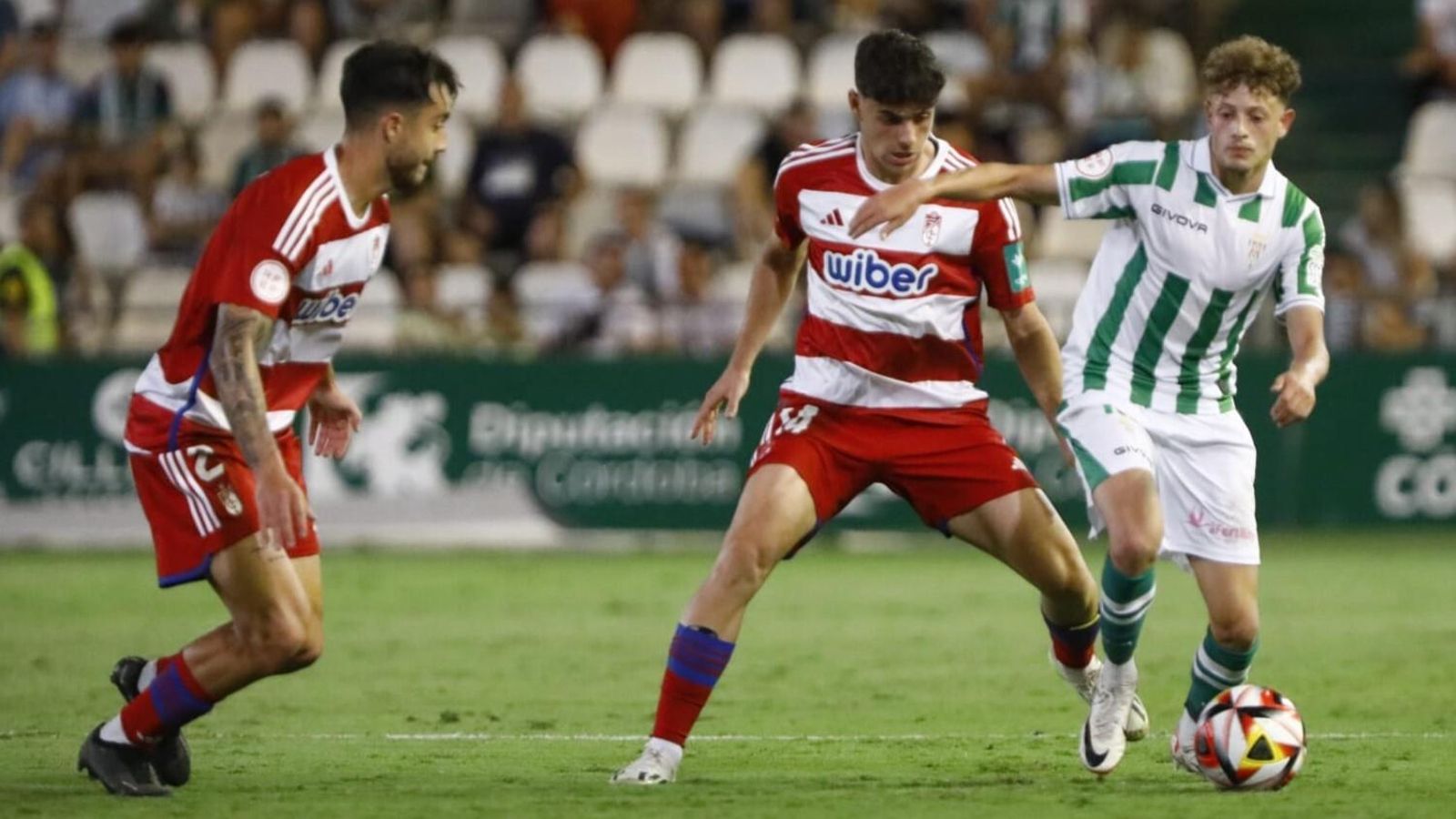 Simo intenta colarse entre dos jugadores rivales en el Córdoba CF- Recreativo Granada. Simo intenta colarse entre dos jugadores rivales en el Córdoba CF- Recreativo Granada.