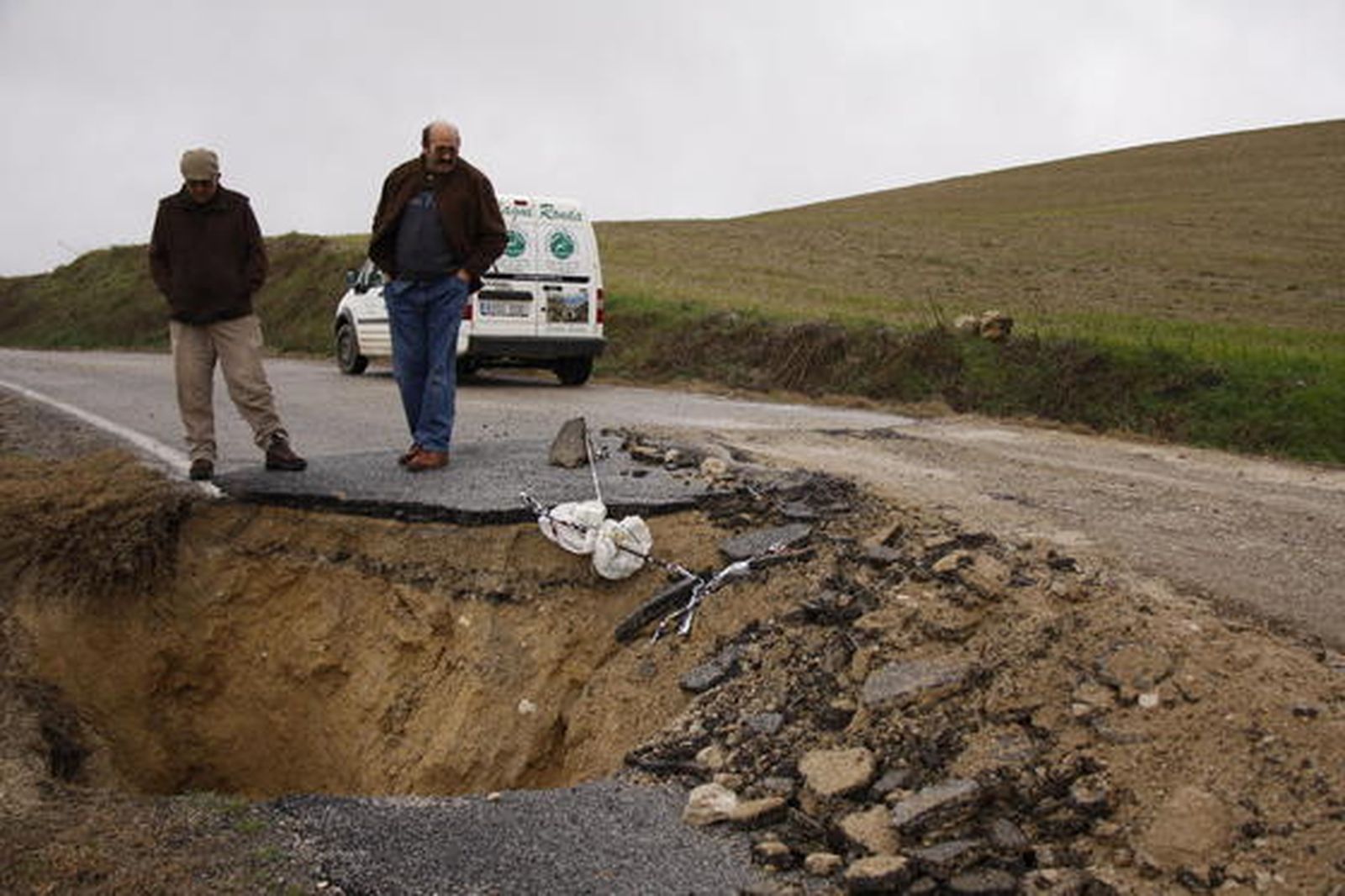 Dos vecinos contemplan los daños del desprendimiento en Puerto Sauco.