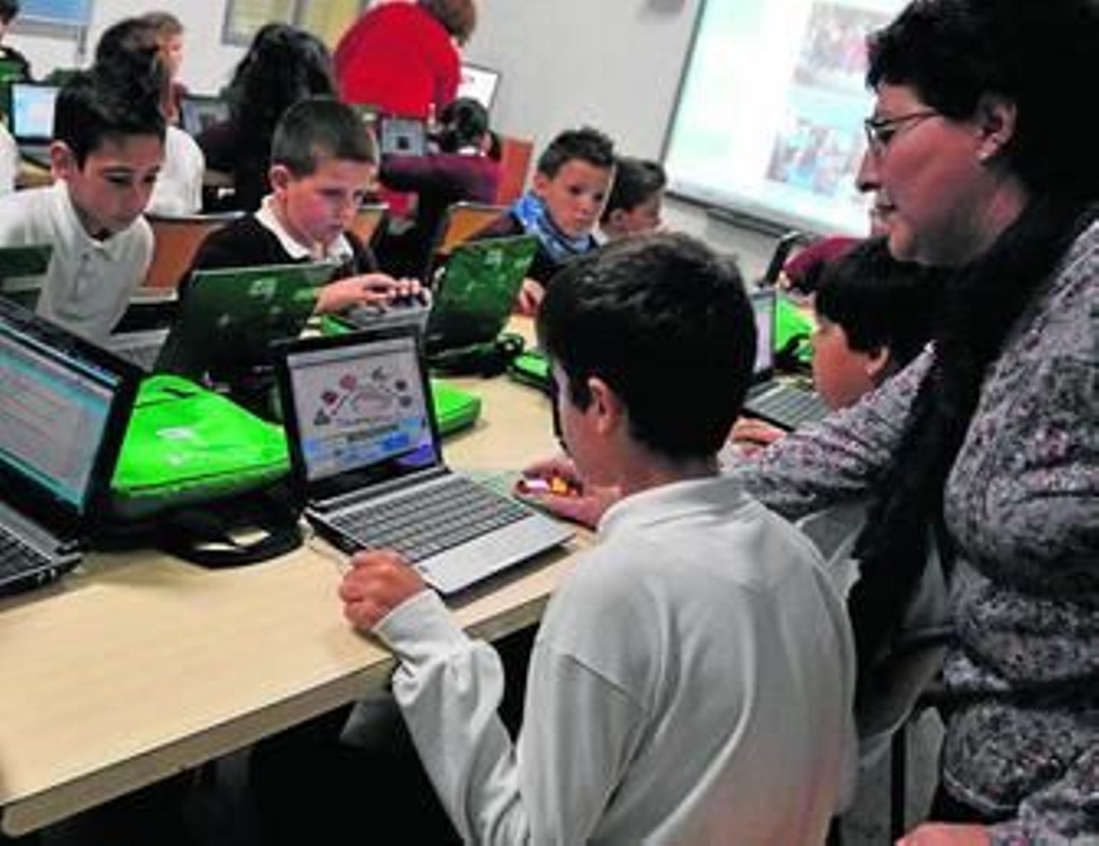 Niños de Primaria trabajando con los ordenadores portátiles.