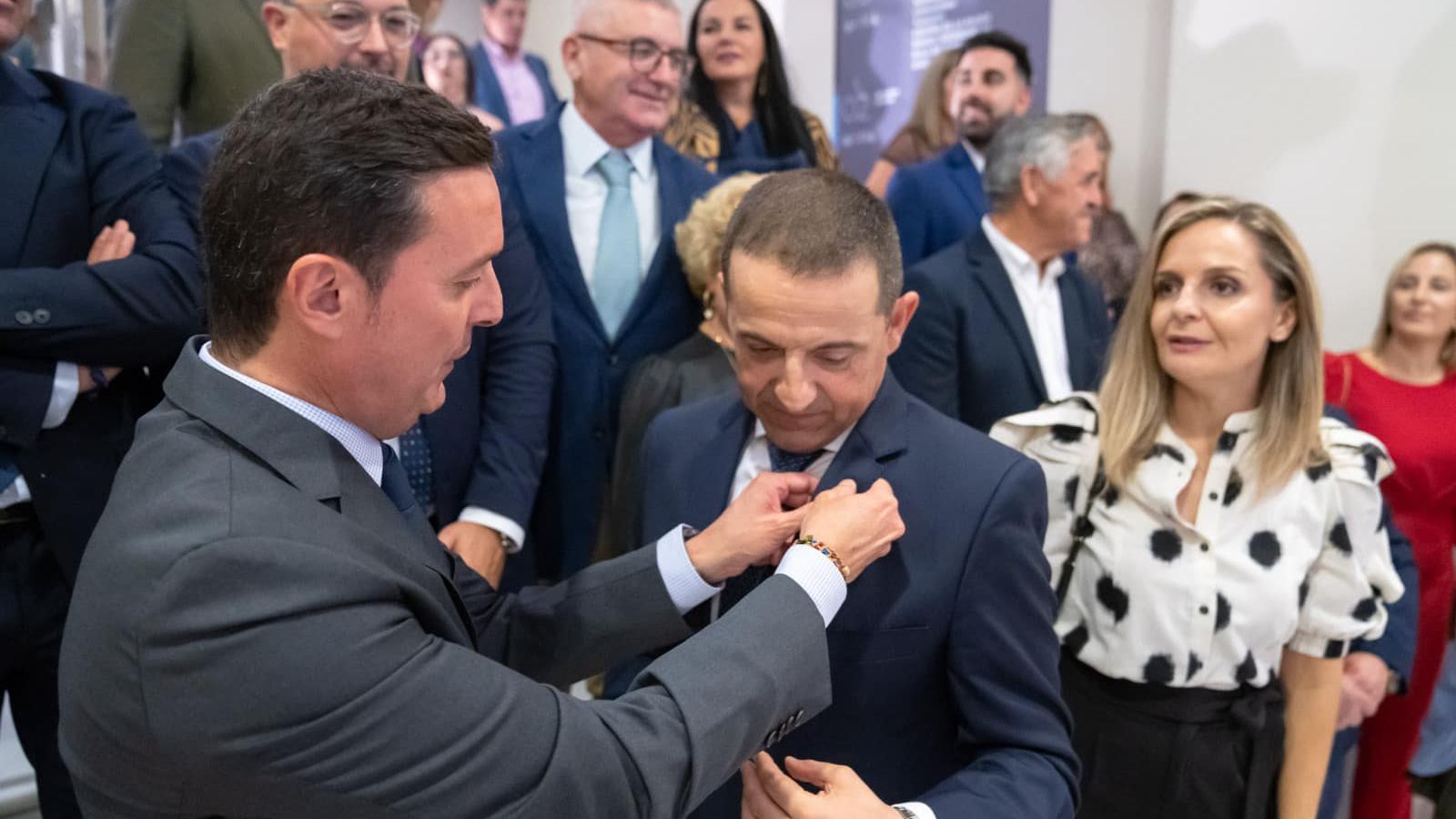 El presidente de la Diputación impone el escudo al pregonero.