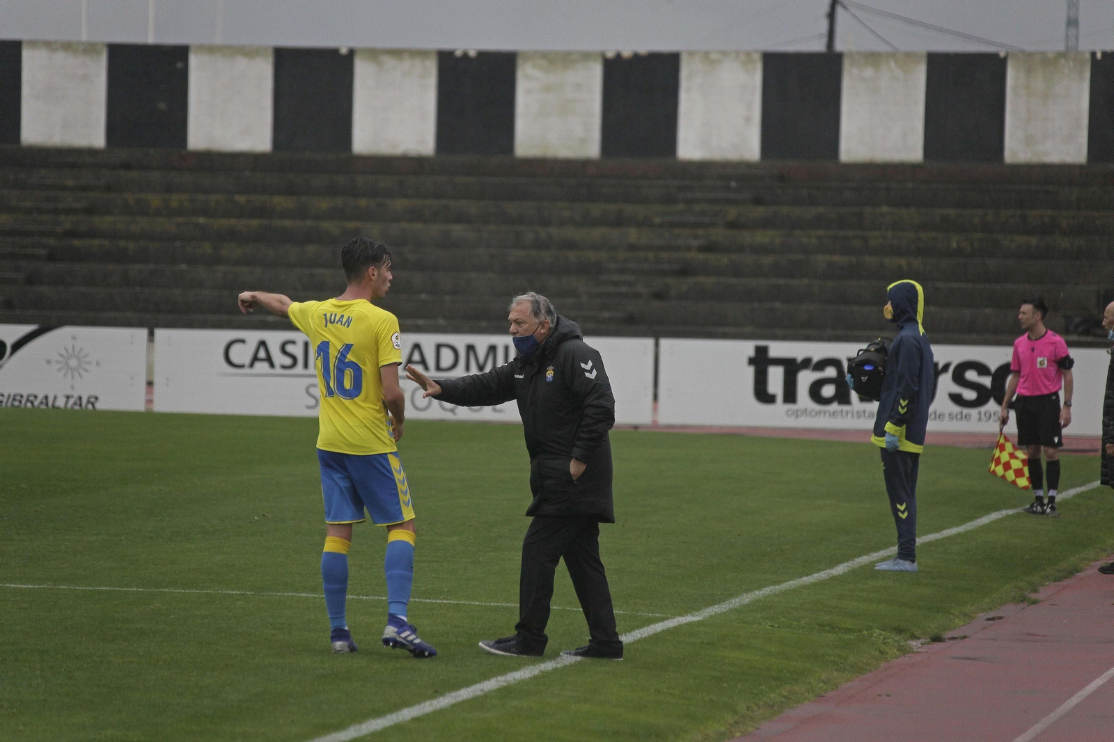 El entrenador de Las Palmas Atlético, da instrucciones a Juan Rodríguez en el Municipal de La Línea