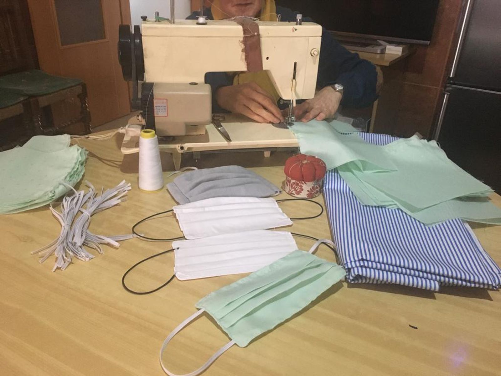 Una vecina de Montefrío tejiendo mascarillas de tela.